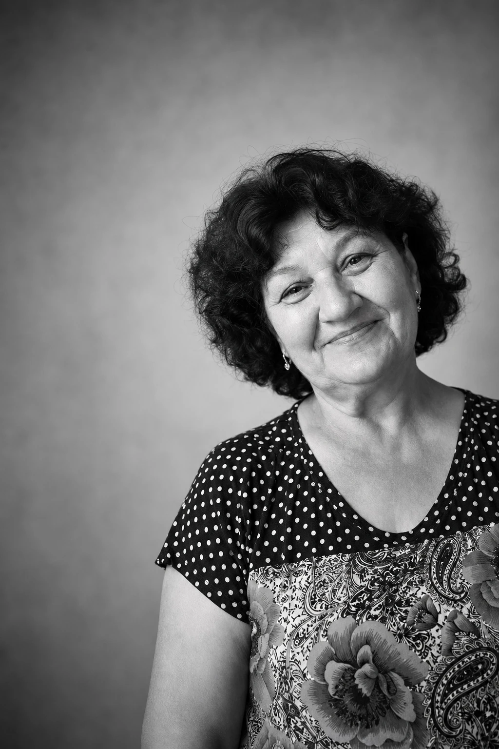 Чорно-біле студійне: Та сама жінка за святковим столом з тортом і квітами, напис «З Днем народження, мамо!».